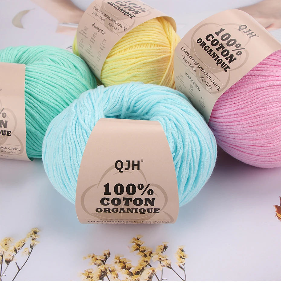 A collection of natural colored organic cotton yarn spools and skeins for knitting and crochet projects.