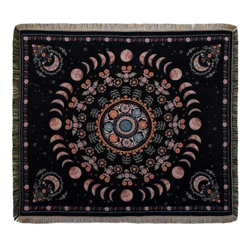 A dark throw blanket featuring a geometric mandala design in shades of pink, orange, and teal.