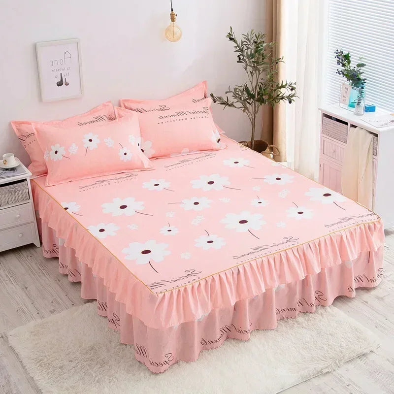 Pink double layer printed bed skirt with white floral pattern and pink pillows on a bed.