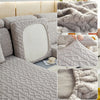 Close-up view of a plush gray velvet sofa cover with a textured knit pattern and anti-slip backing.