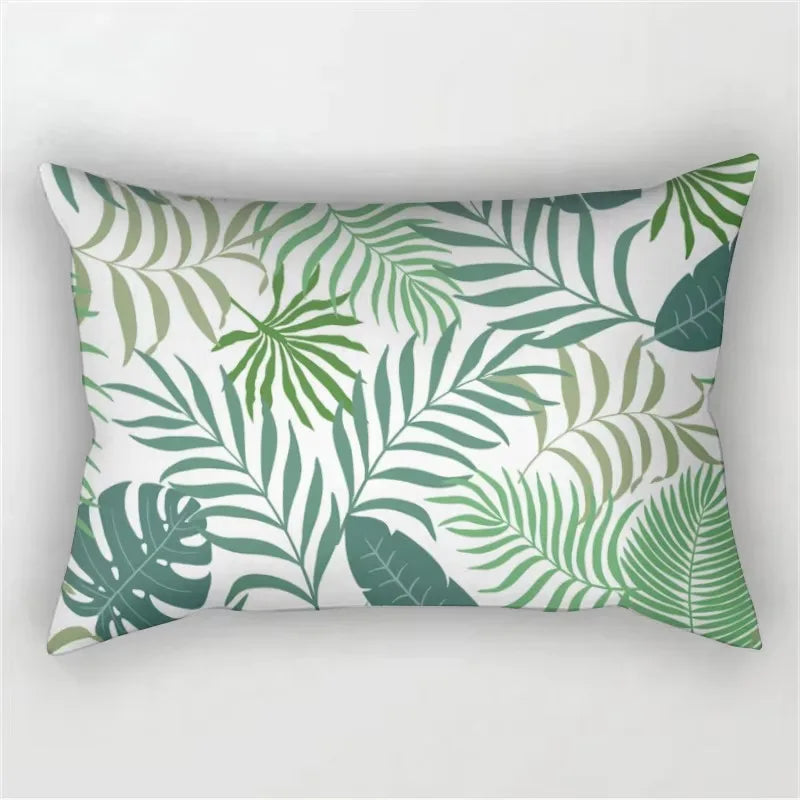 A decorative pillowcase featuring a tropical leaf print in shades of green and white.