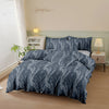 A navy blue botanical print duvet cover set displayed on a bed with white bedside tables and natural light.