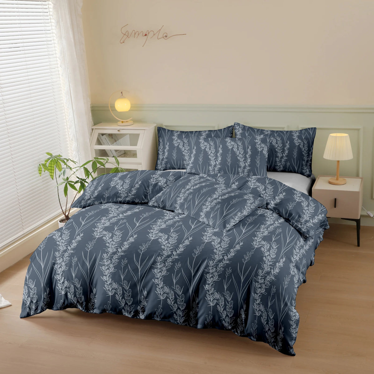 A navy blue botanical print duvet cover set displayed on a bed with white bedside tables and natural light.