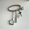 Silver star pocket watch keychain with an adjustable clock and a small blue charm