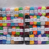 A collection of 12 colors of milk cotton yarn in skeins arranged in rows for a crochet kit.