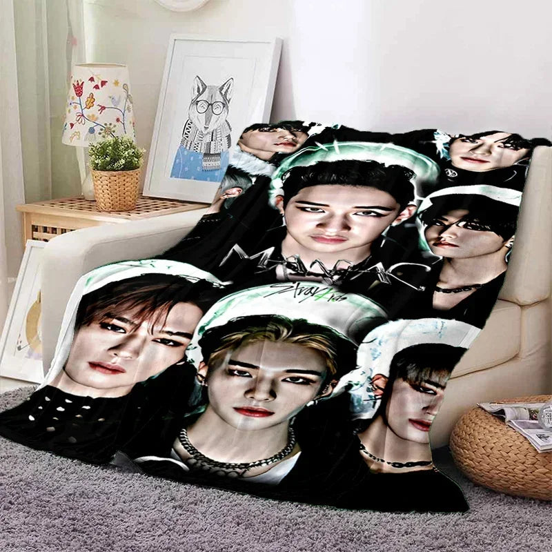 A fleece throw blanket featuring multiple 3D printed portraits of Stray Kids members.