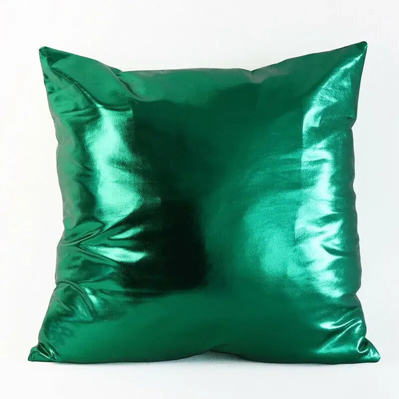 A square pillow covered in metallic, shiny emerald green fabric.
