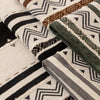 Close-up of patterned bohemian chenille sofa cushion covers featuring geometric designs in earth tones and black.