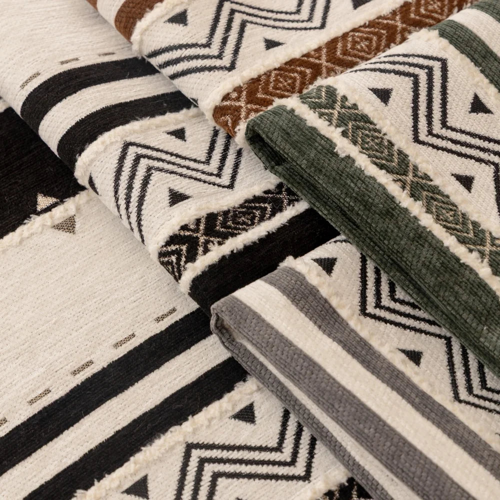 Close-up of patterned bohemian chenille sofa cushion covers featuring geometric designs in earth tones and black.