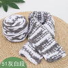 A bundle of gray and white striped chenille knitting yarn resting on a woven mat.