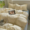 A light yellow floral microfiber duvet set with matching pillows and a stuffed bunny toy on a bed.