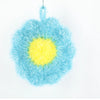 A blue and yellow flower-shaped kitchen dish scrubber sponge with a fluffy texture.