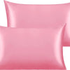 A stack of silky satin toddler pillows in a soft pink color.
