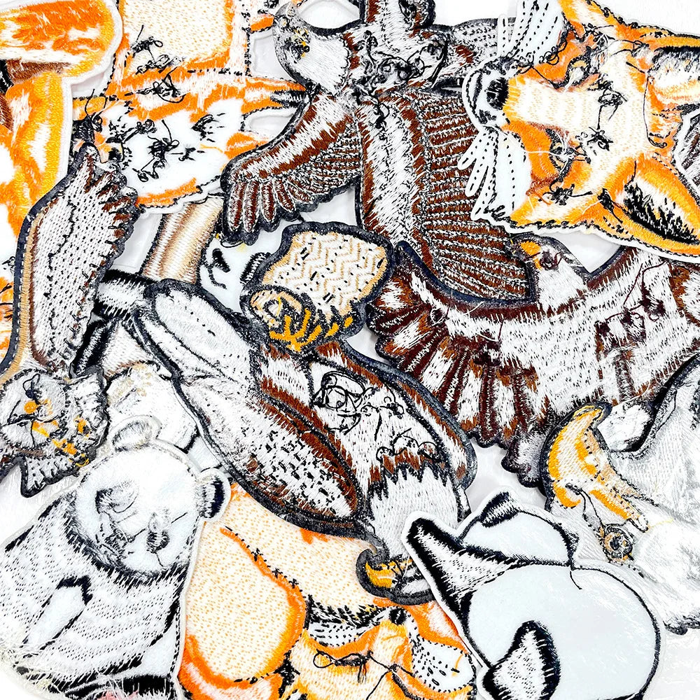A collection of animal embroidery patches featuring tigers, bears, and other wildlife in various colors and textures.