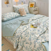 A light blue summer gauze cotton quilt spread on a bed with white and beige decor.