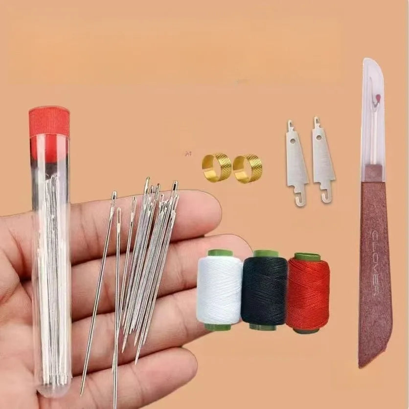 A hand shows a precision hand sewing kit including a glass tube, steel needles, and spools of thread.