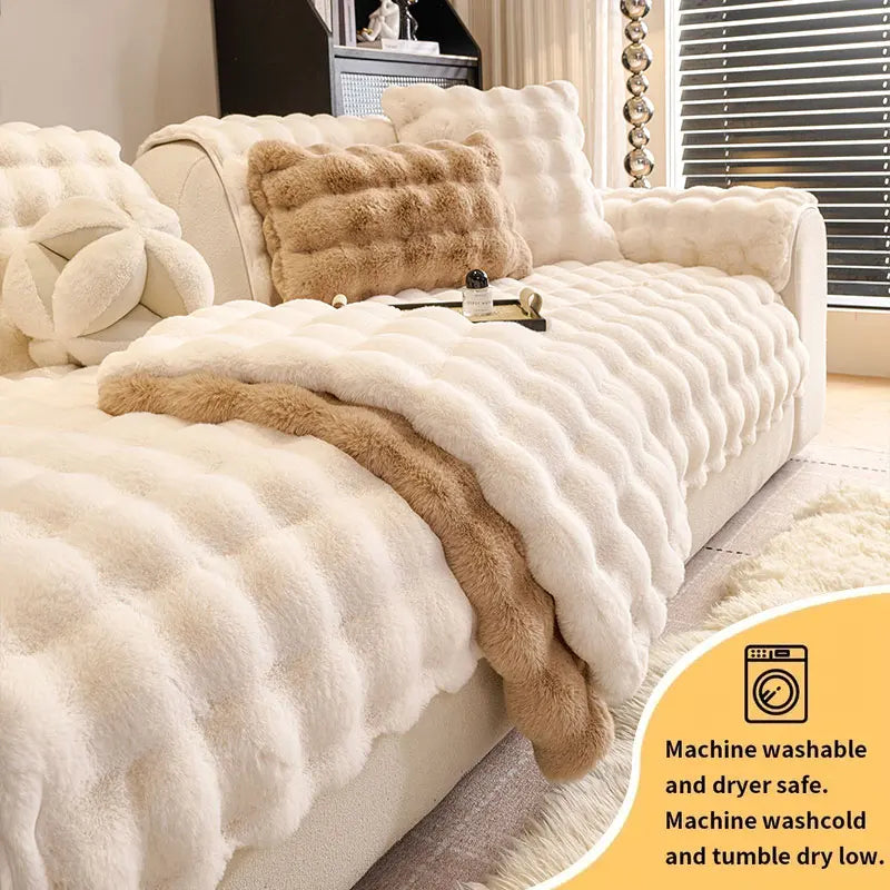 A cream colored plush sofa cushion with a brown faux fur accent, showing machine washable and dryer safe features.