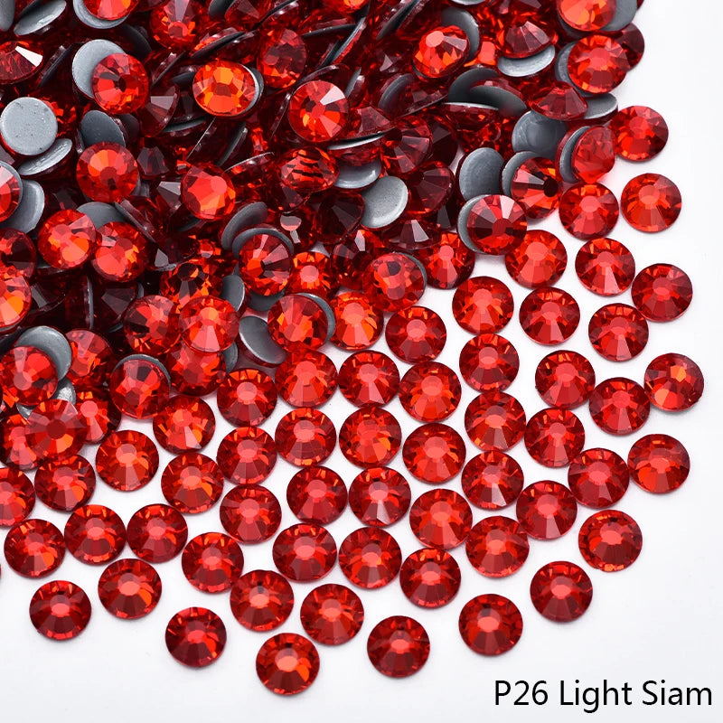 A close-up view of red glass rhinestones scattered on a white background.