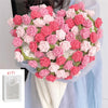 A bouquet of handmade rose crochet flowers in pink and red shades displayed against a light blue fabric.