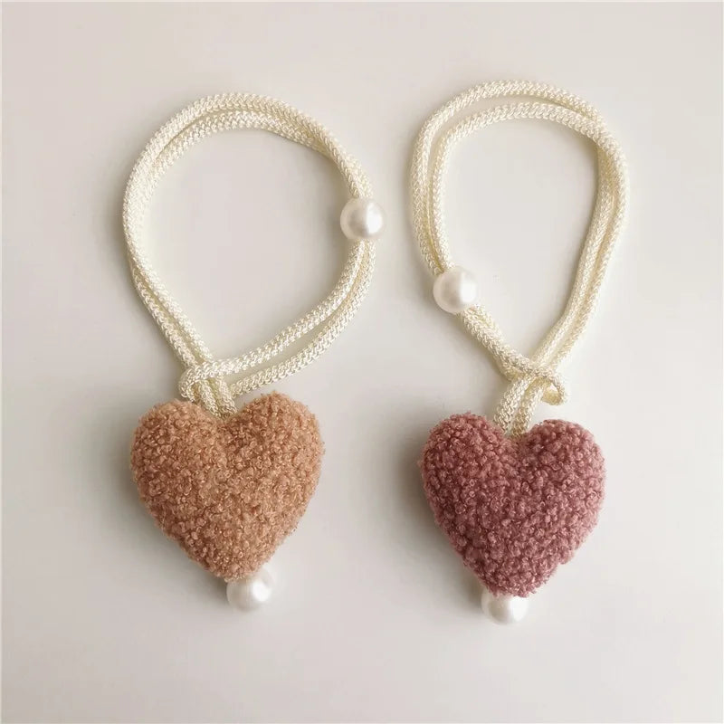 Pair of cream-colored plush heart tiebacks with pearl accents.