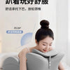 A woman is using a gray ergonomic memory foam wedge pillow for neck support while relaxing in bed.