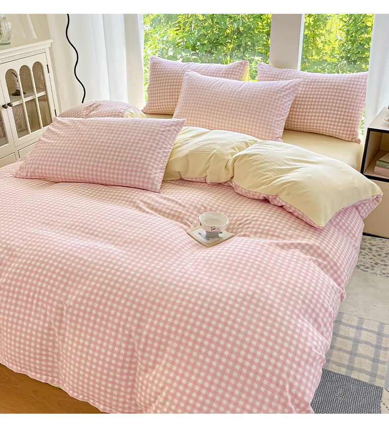 A pink and white checkered duvet cover set displayed on a bed with matching pillows.