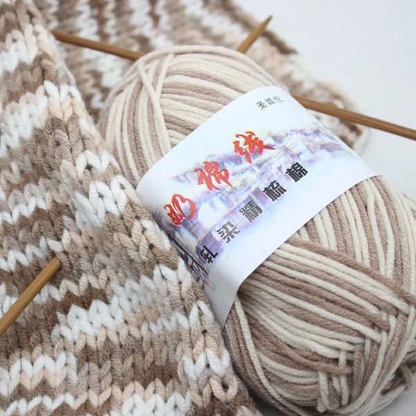 A ball of beige premium milk cotton yarn is shown next to knitting needles and a textured knitted fabric.