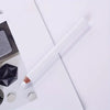 A white bamboo chalk pencil is shown diagonally on a white surface next to various fabric marking stones.
