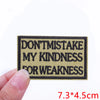 A rectangular black embroidered patch with beige text that reads DON'T MISTAKE MY KINDNESS FOR WEAKNESS