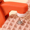 An orange precision snap button kit component is shown resting on a pink knitted fabric.