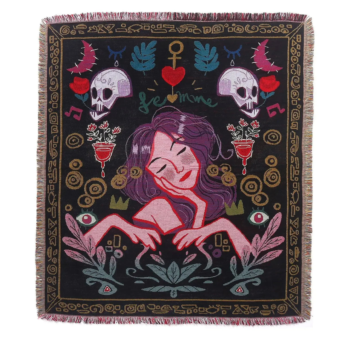 A dark geometric throw blanket featuring a stylized female face surrounded by floral and skull motifs in earthy tones.