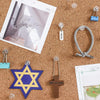 A collection of transparent round head push pins, a Star of David, and a wooden cross scattered on brown cork board.
