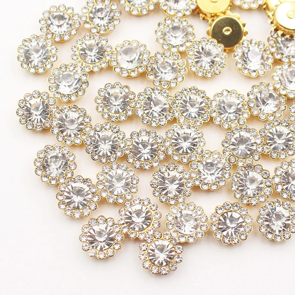 A close-up of gold and clear crystal rhinestone sew-on buttons arranged in a sunflower pattern.