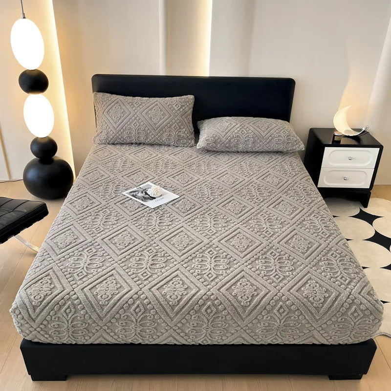 A gray plush jacquard mattress cover on a black bed with white accent lighting.