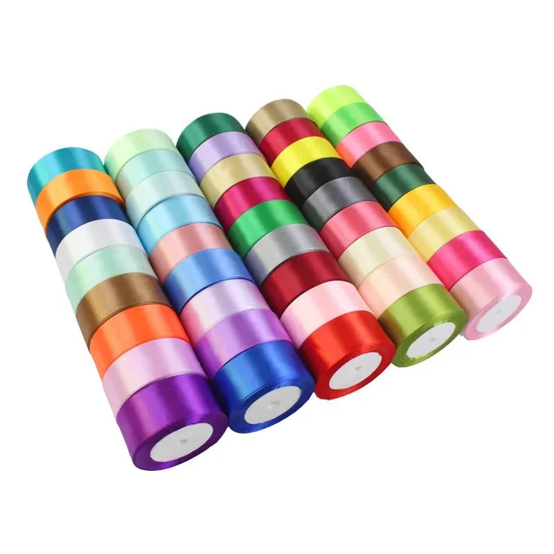 A collection of rolled satin craft ribbons in various bright colors like yellow, green, pink, and purple.