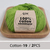 A ball of bright green 100% organic cotton yarn labeled QJH with environmental protection dyeing details.