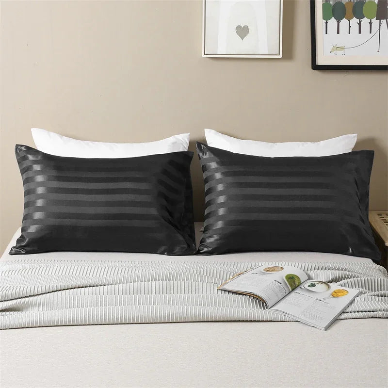 Black and gray striped pillow covers with white pillowcases displayed on a bed.