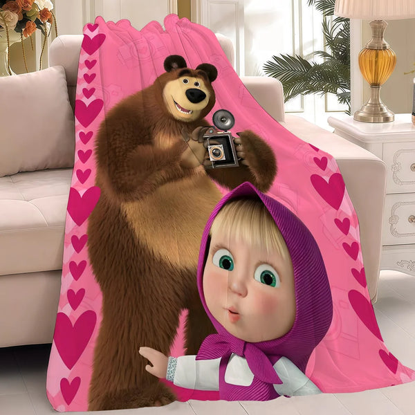 A plush blanket featuring a cartoon bear and a baby character in pink and purple tones.