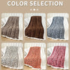 A collection of leopard print jacquard knit throw blankets in various shades and textures displayed on a light wooden surface