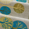 Close-up of a beige woven fabric featuring stylized blue and olive green leaf patterns.