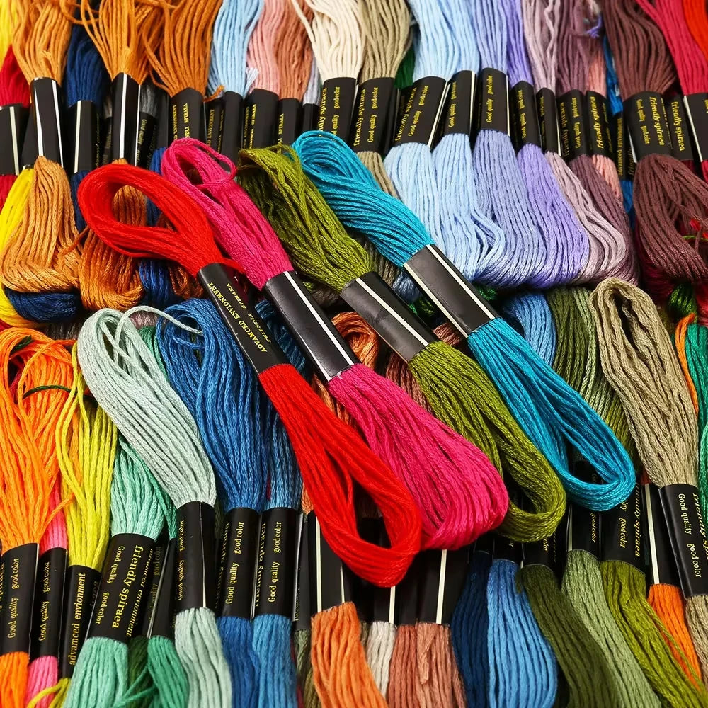 A close-up view of various strands of colorful embroidery floss threads in a variety of hues and textures.