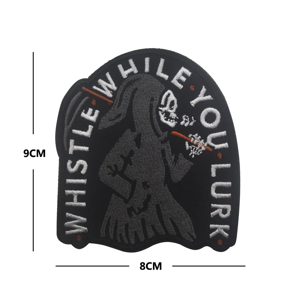 Black glow in the dark biker patch featuring a skull silhouette and the text WHISTLE YOU LURK