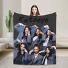 A black blanket featuring a collage of nine young women in matching gray jackets and ties, with the name Katseye written acro