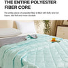 A light mint green quilted polyester fiber core blanket is shown being held, ready for summer comfort.