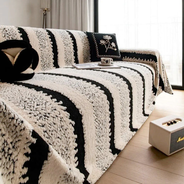 A close-up of a bohemian striped jacquard sofa throw featuring black and white textured stripes on a sofa.