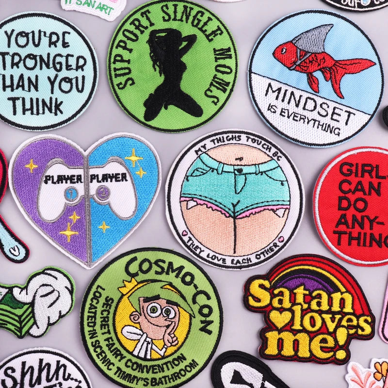 A collection of embroidered letter iron-on patches featuring various sayings and designs on a light gray background.