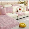 A plush velvet sofa cover in pink and cream tones with quilted cushions and a yellow decorative ball.