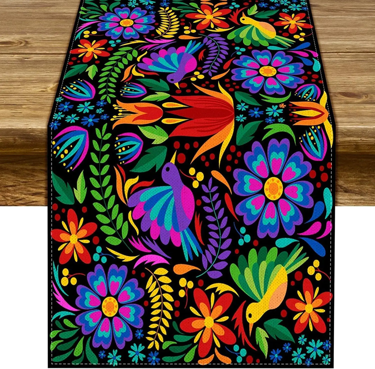 Vibrant floral pattern on a black linen table runner featuring bright colors like red, orange, purple, and green.