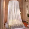 White sheer mosquito net canopy draped over a bed, providing a protective barrier.