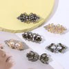 A collection of vintage swirl clip brooches in silver and gold tones displayed on a light yellow background.